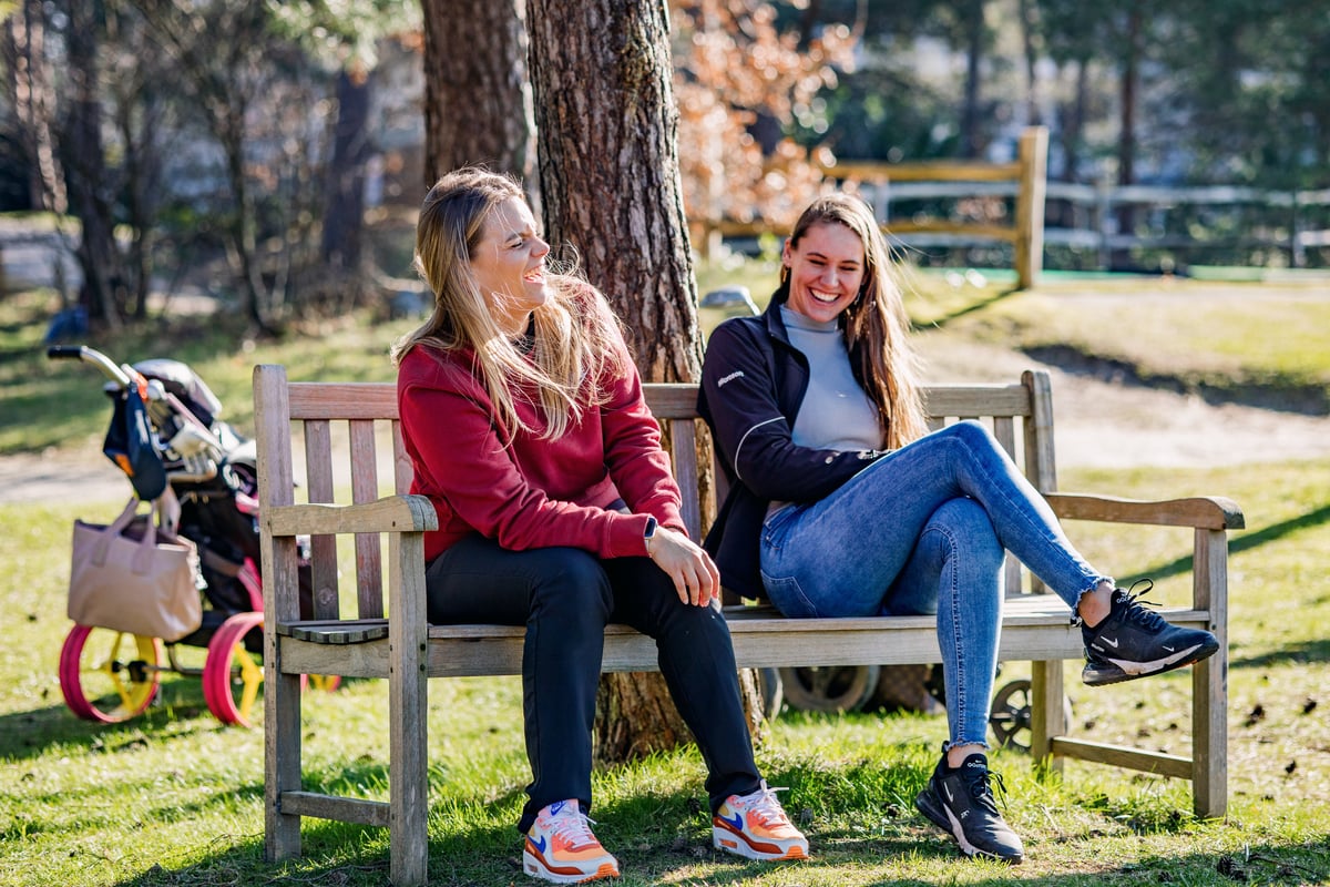 Female golfers sitting on a bench. Photo_ Renate Roeleveld